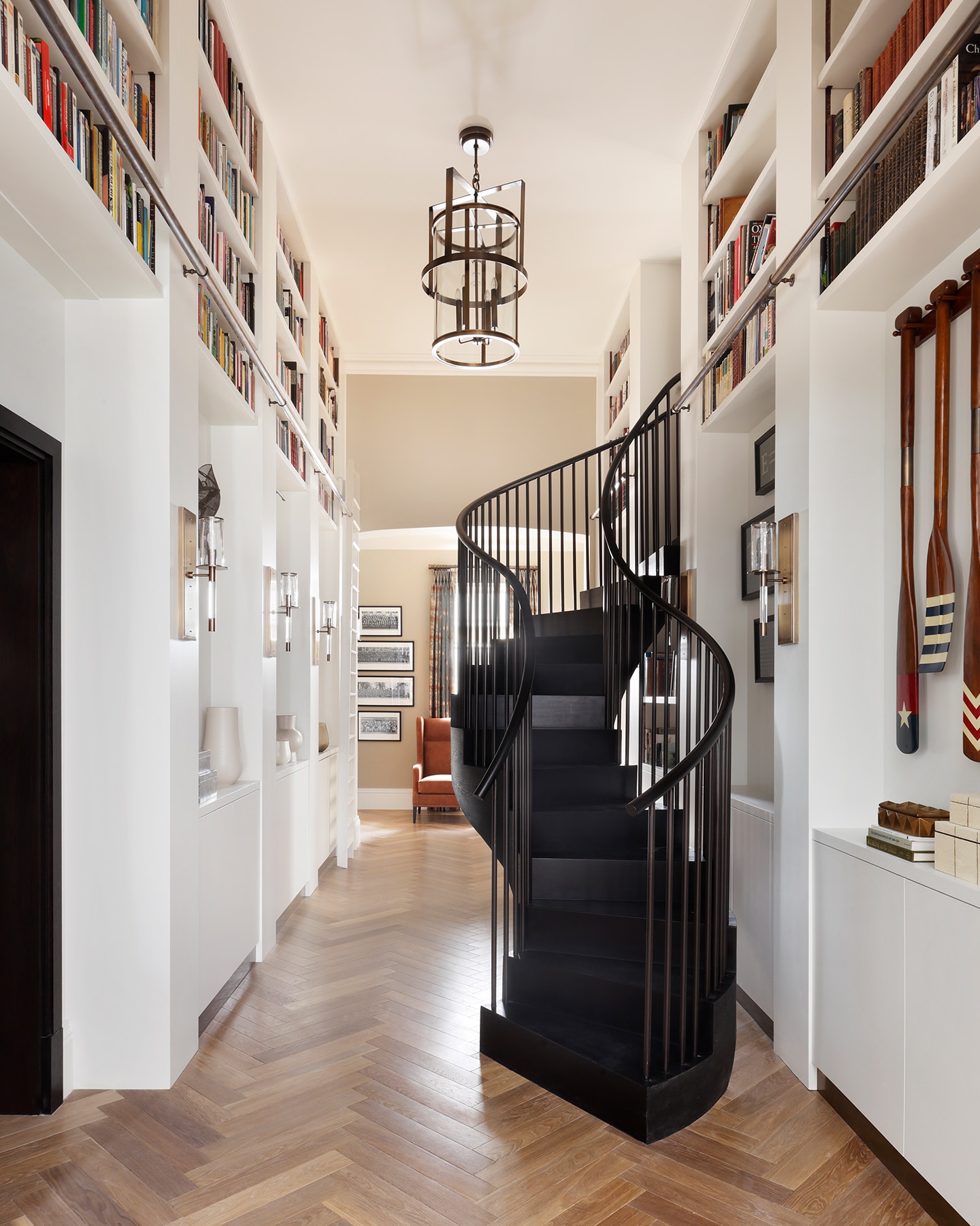 Spiral staircase and large bookshelves lining walls.